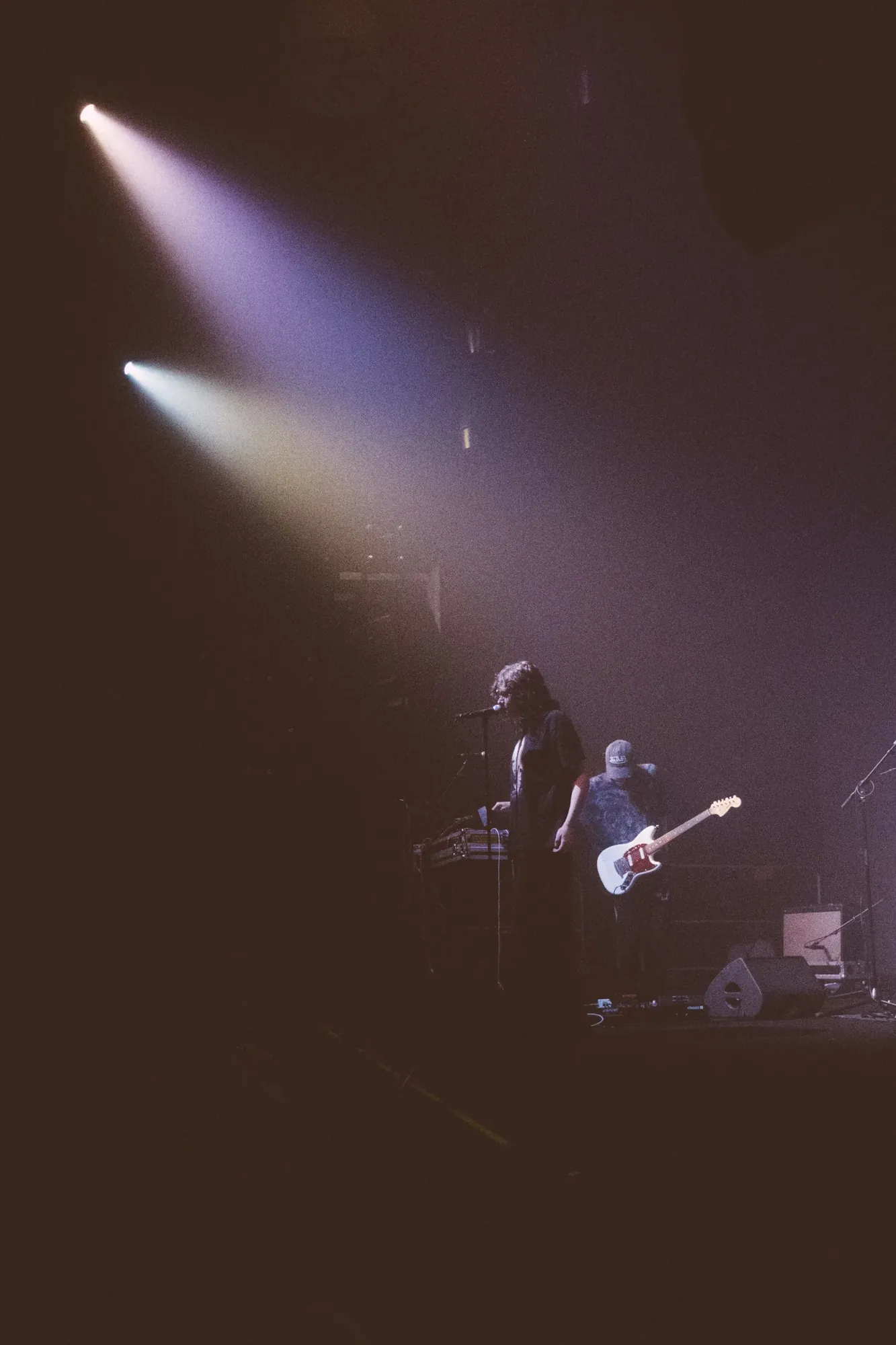 Musicians performing beneath purple-white spotlights, photographed by Helen Milova