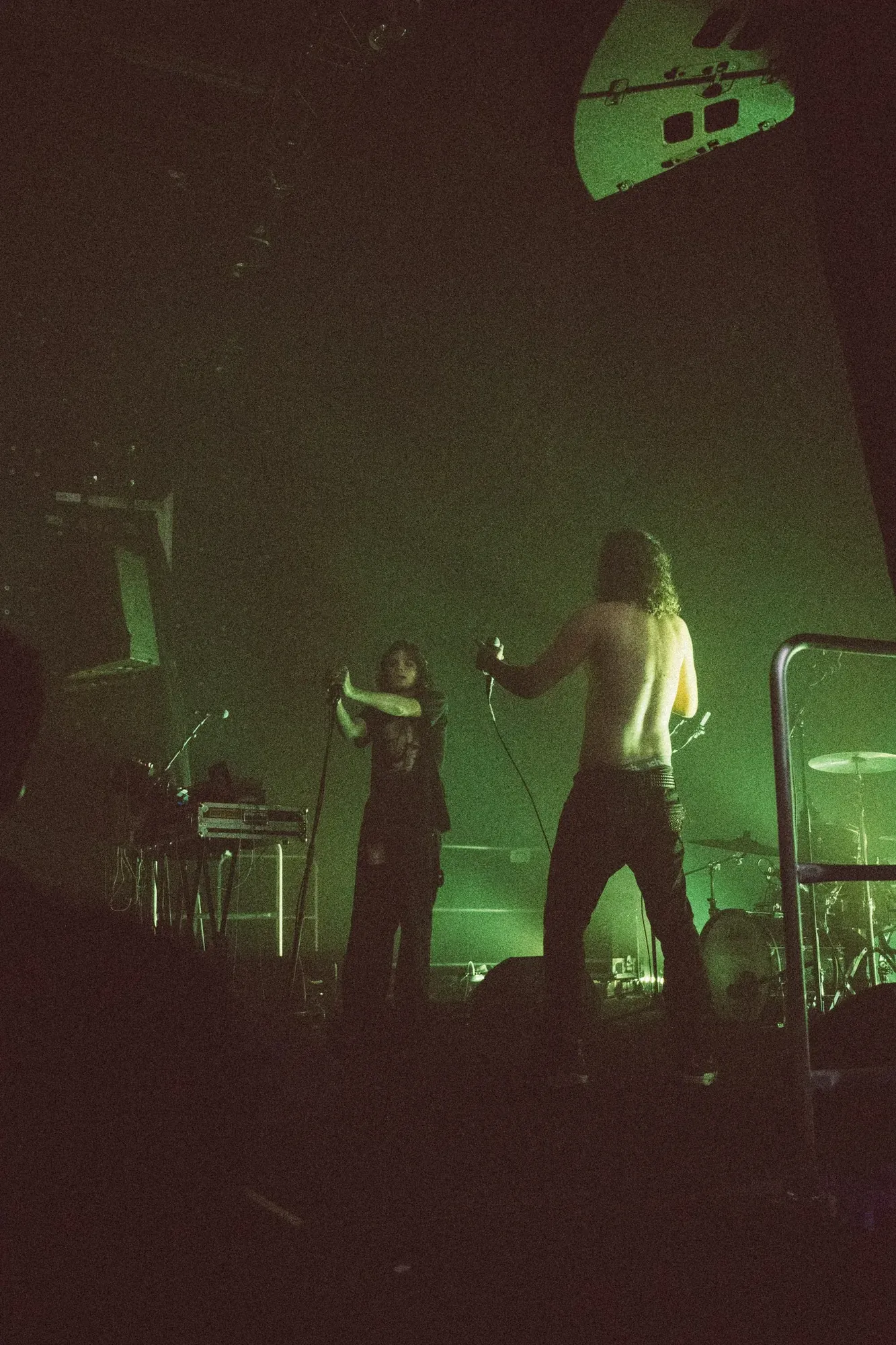 Performer in green stage light, photographed by Helen Milova