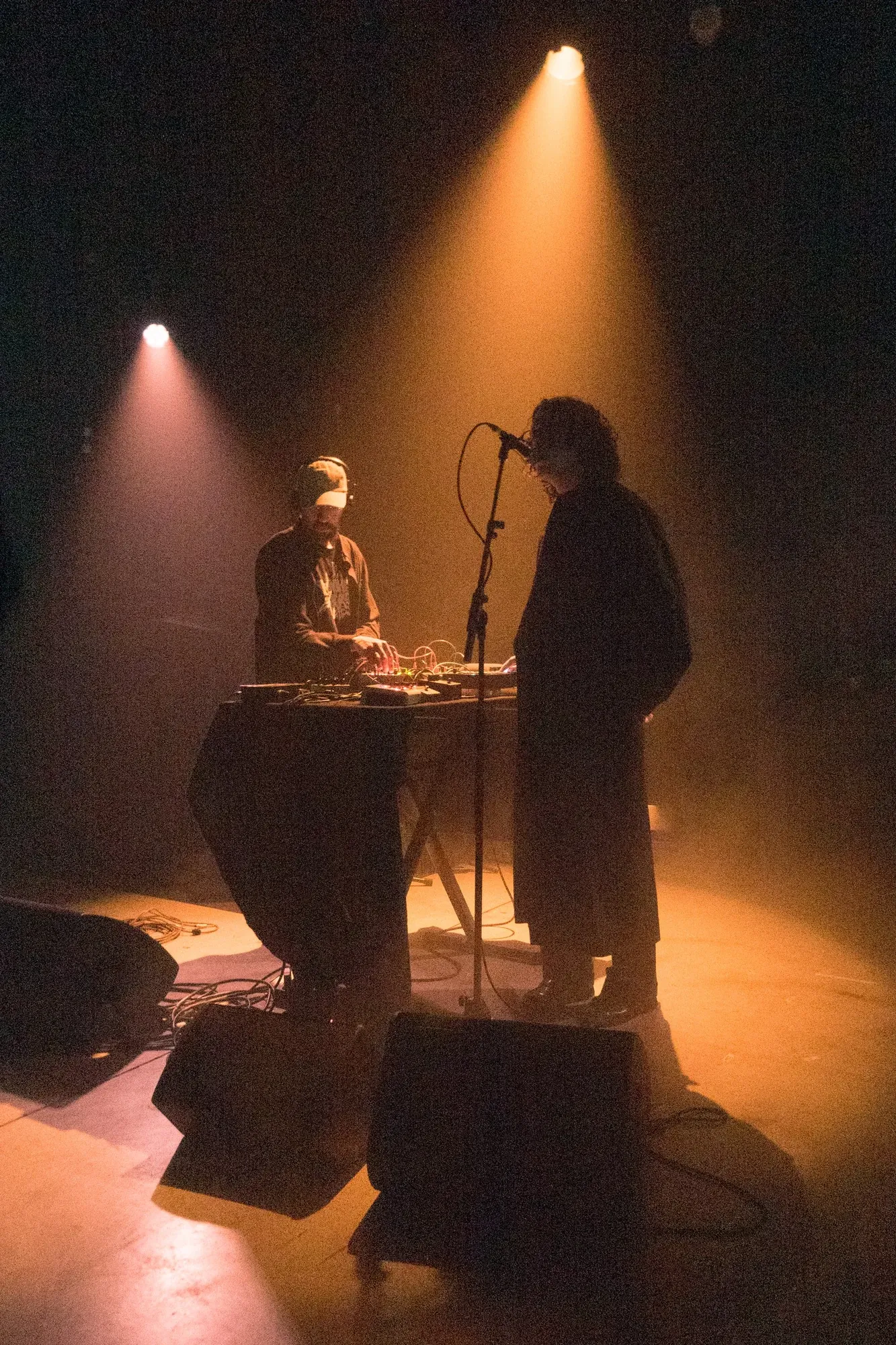 Two musicians performing under warm stage light, photographed by Helen Milova