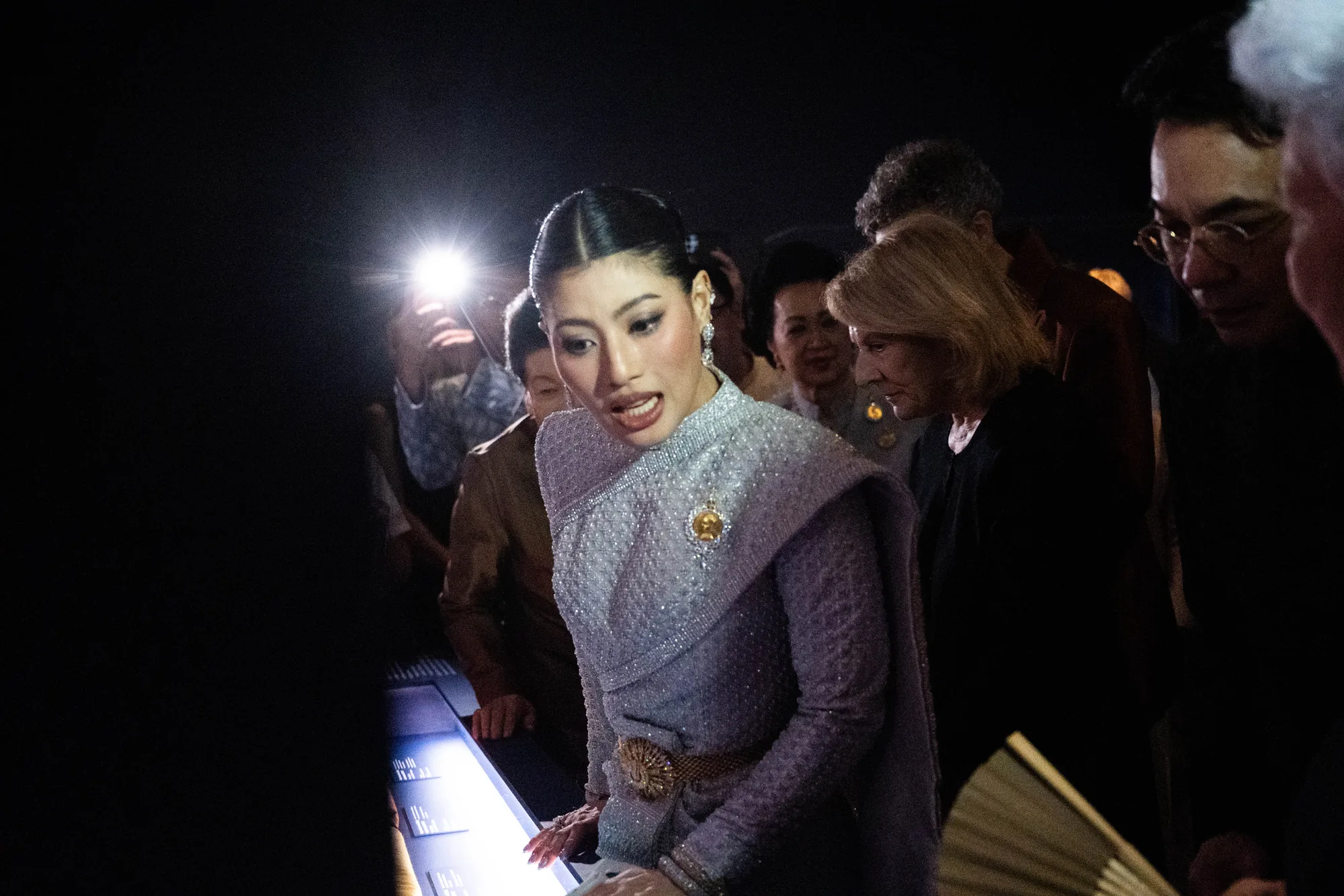 Guest surrounded by a crowd and camera light, photographed by Helen Milova
